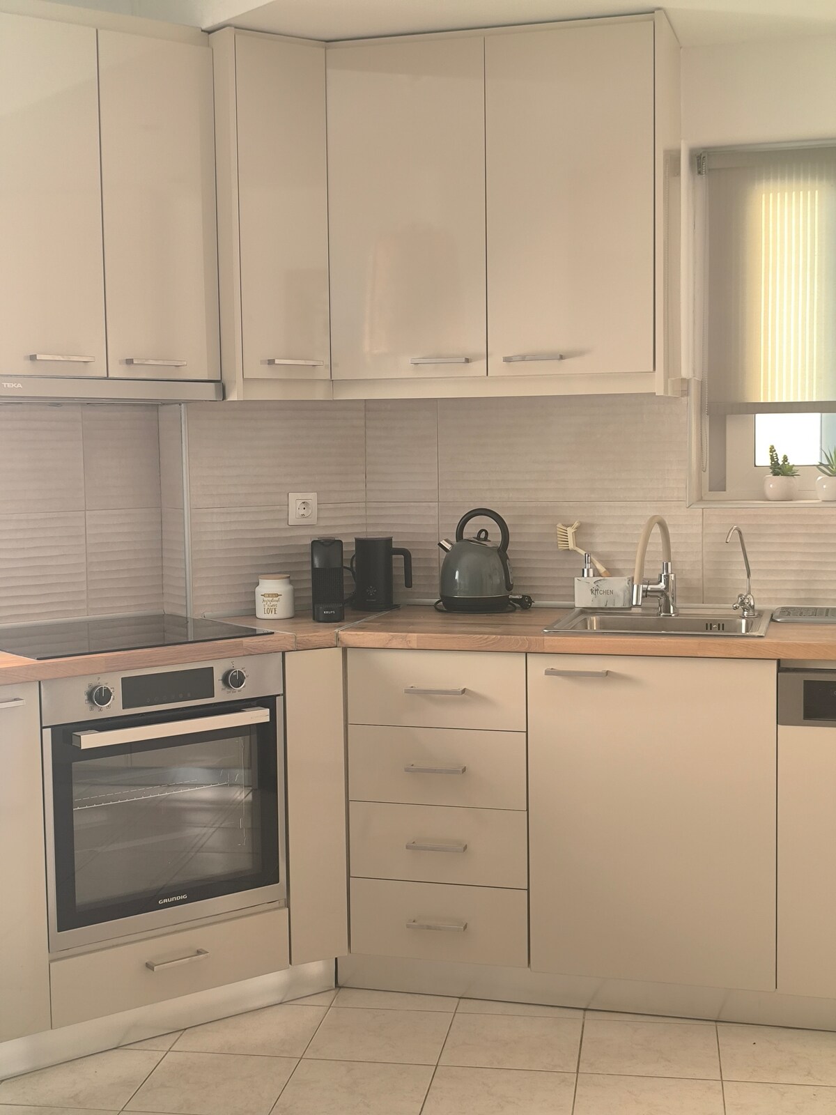 Küche mit Induktionsherd, Backofen, Kleingeräten und Spülmaschine